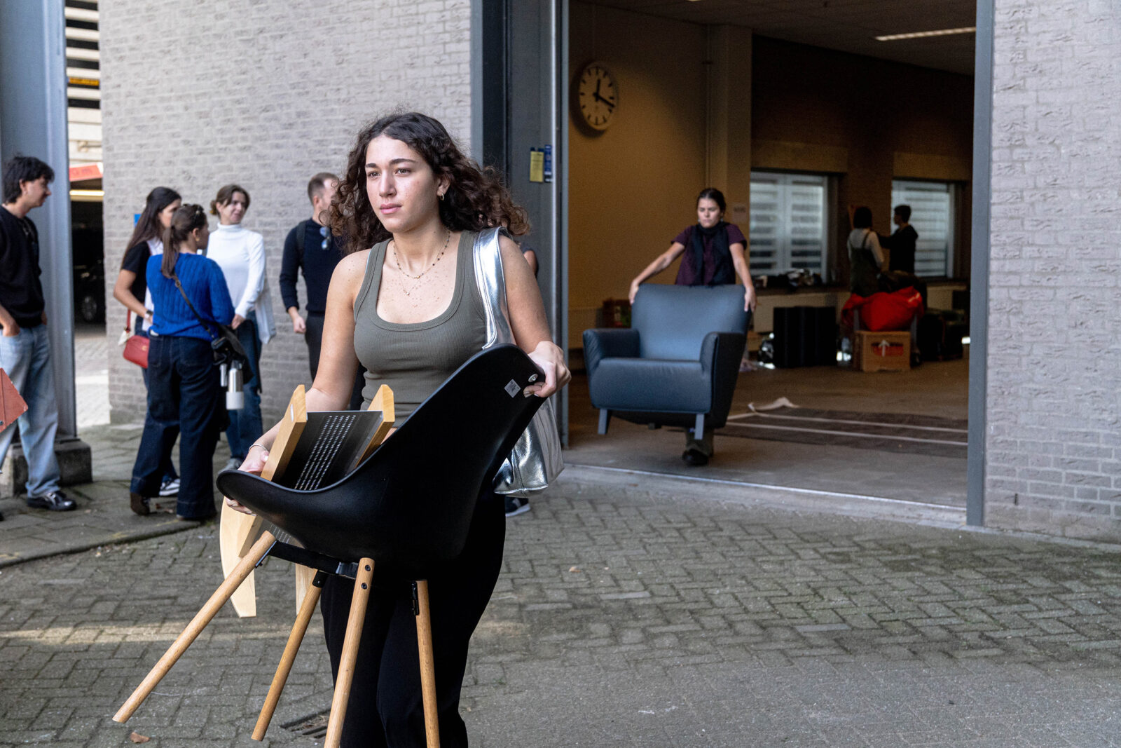 A student carries a free chair outside