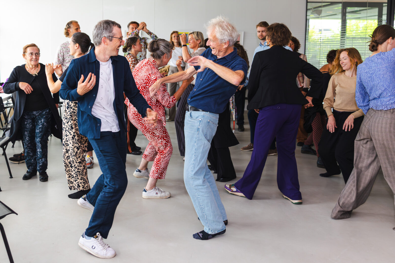 Deelnemers van een van de workshops bewegen mee op de muziek