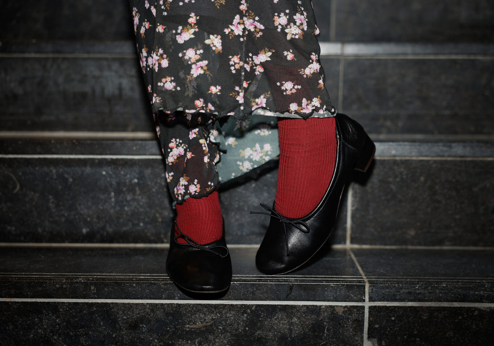 Narmin draagt bordeauxrode sokken in haar nieuwe zwarte ballerina's met een kleine hak