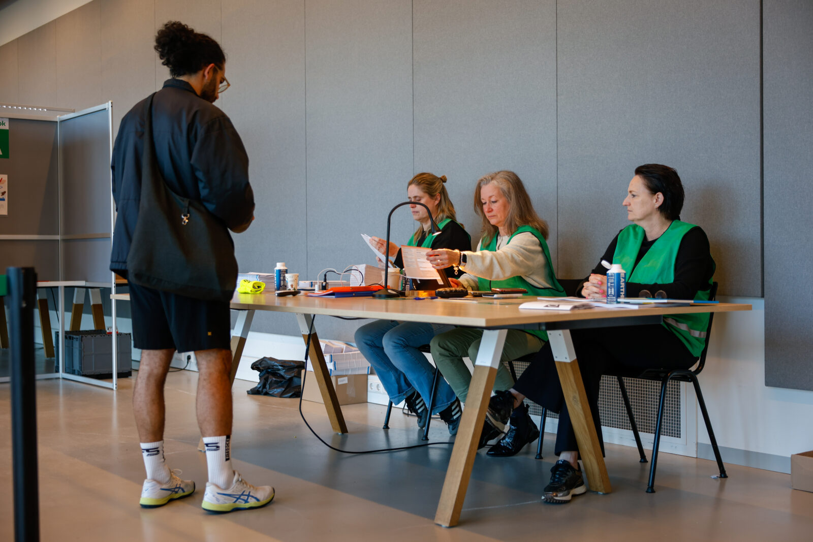 Het stembureau controleert de stempas van een kiezer